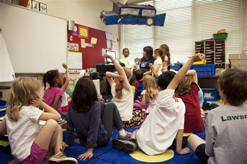 Young learners raising their hands in class
